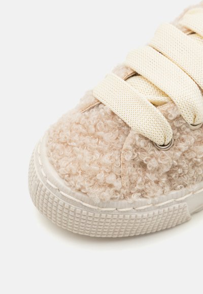 Baskets beige avec un dessus texturé et duveteux, lacets crème et semelle en caoutchouc. Présente des œillets ronds et un design de coque de pied sans couture.