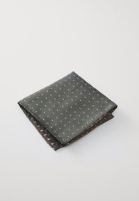 Pochette en soie, vert foncé avec de petits motifs blancs et orange. Le design plié révèle un motif à carreaux au dos.
