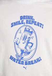 White t-shirt featuring blue graphic design of a smiling water bottle with text: "Drink, Smile, Repeat! Water Break!" and Puma logo.