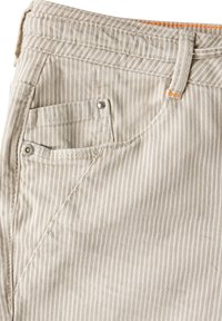 Beżowe spodnie bawełniane w paski, o klasycznym kroju, z przednią kieszenią ozdobioną metalowym gwoździem oraz pomarańczowym akcentem na pasku.