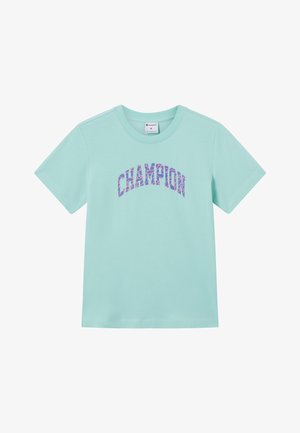 Lichtblauw T-shirt met korte mouwen en ronde hals, met de tekst "CHAMPION" in een paarse en roze mozaïekpatroon over de borst.
