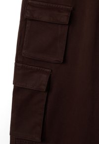 Braune Cargo-Hosen mit mehreren aufgesetzten Taschen, robustem Stoff und glatter Textur sowie sichtbaren Nähdetails.