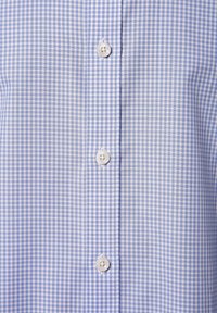 Hellblau-weiß karierter Hemd mit Knopfleiste, das kleine Karomuster und runde weiße Knöpfe aufweist. Glatte Stoffstruktur.