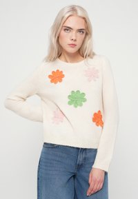 Κρεμ ζακέτα με λουλουδάτη κεντητική σε ροζ, πορτοκαλί και πράσινο. Πλέξη, στρογγυλή λαιμόκοψη και ριμπ φινίρισμα. Χαλαρή εφαρμογή.