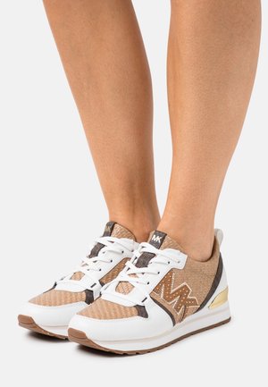 Baskets présentant une tige tissée de couleur beige avec des accents en cuir blanc, un détail doré au talon, et des lacets noirs et blancs.