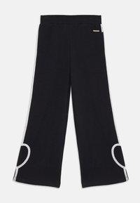 Svart vide bukser laget av mykt stoff, med hvite side-striper og et utskåret akzent, samt elastisk midjebånd for komfort.