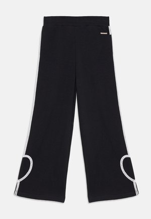 Schwarze weit geschnittene Hosen aus weichem Stoff, mit weißen Seitenstreifen und einem Cutout-Detail, sowie einem elastischen Taillenbund für zusätzlichen Komfort.