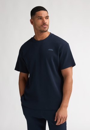Marineblauw, gestructureerd T-shirt met een ronde hals en korte mouwen, voorzien van een klein lichtblauw logo op de borst en een comfortabele, losse pasvorm.