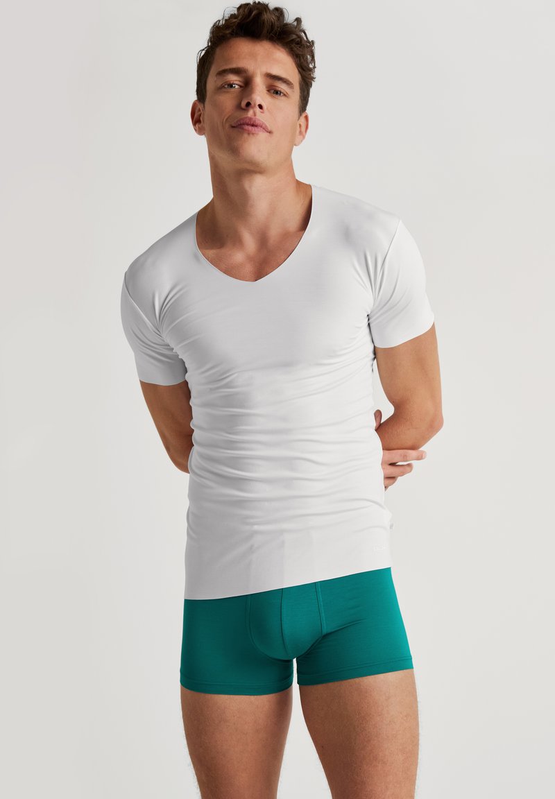Witte katoenen V-hals t-shirt met korte mouwen gecombineerd met teal katoenen boxers, gladde textuur, aansluitend ontwerp en minimale merkbranding.