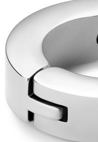 Rund metallisk ring med en polert sølvfinish, som har et sømløst design og en liten spalte som fremhever konstruksjonen.