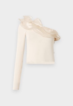 Asymmetrische crèmewitte top met één lange mouw, voorzien van een doorschijnende ruches aan de halslijn en een gladde, aansluitende stof.