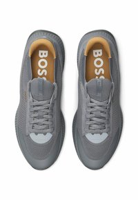 Gray athletic shoes with mesh upper, rubber sole, and lace-up design. Interior features tan lining with "BOSS" branding on insoles.