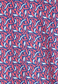 Tissu en coton présentant un motif répétitif de formes tourbillonnantes en rouge, bleu et blanc, avec une texture lisse et un contraste de couleurs vif.