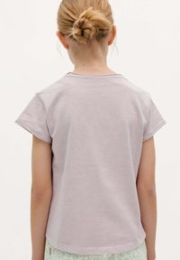 Lichtpaarse t-shirt met korte mouwen, een ronde halslijn en een relaxed fit, gemaakt van zacht katoenmateriaal. Glad textuur met gestikte randen.