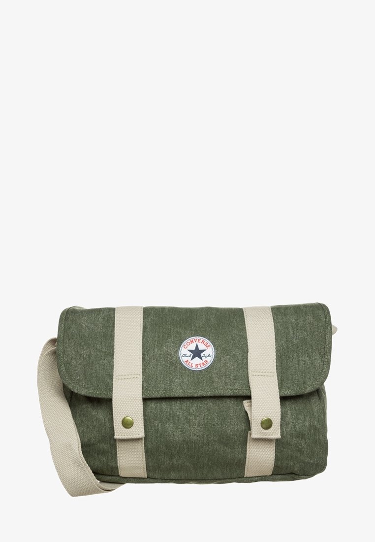 Borsa a tracolla verde in tela con patta pieghevole, spallacci crema, accentuazioni in metallo e una toppa rotonda con logo Converse sulla parte anteriore.