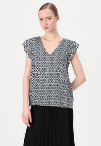 Kortärmad blus med ett navy- och vitt geometriskt mönster, V-ringning och volangärmar, tillverkad av lättviktig tyg.