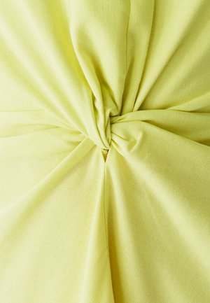 Tessuto giallo con una trama testurizzata, caratterizzato da un dettaglio di nodo intrecciato al centro. Superficie liscia con sottili effetti di drappeggio.