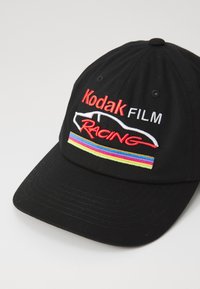 Czarna czapka baseballowa z haftowanym napisem "Kodak FILM" oraz "RACING" w czerwonym, białym i kolorowym pasku na przedniej części.