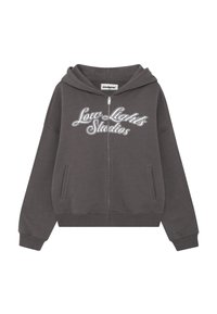 Felpa grigia con zip realizzata in tessuto morbido, caratterizzata da un grande logo bianco "Low Lights Studios" sul davanti e tasche laterali.