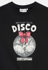 Svart skjorte med en sølv disco kule dekorert med en stor rosa sløyfe og teksten "Møt meg på DISCO" over.