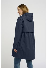 Veste à capuche bleu marine à coupe décontractée, avec un design de couture au dos et des manches longues, fabriquée à partir d'un tissu texturé.