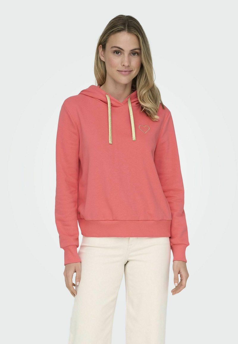 Sudadera de color coral con un bolsillo frontal, cordones dorados y un pequeño bordado de corazón dorado en el lado izquierdo del pecho. Tela suave y casual.