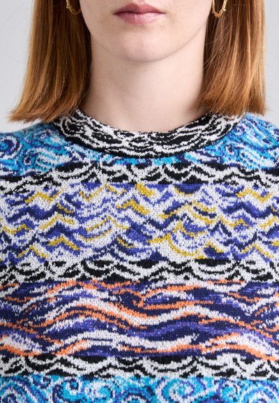 Knit sweater featuring a crew neck, multicolored patterns of waves in blue, yellow, orange, and black on a white background.