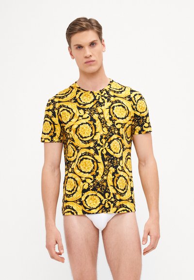 Black T-shirt featuring a yellow floral and baroque pattern, short sleeves, round neck, and a fitted design.