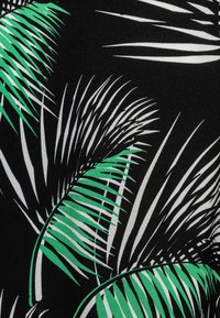 Svart tyg med ett tropiskt palmblads mönster i grönt och vitt. Bladen varierar i storlek och form, vilket skapar en dynamisk design.