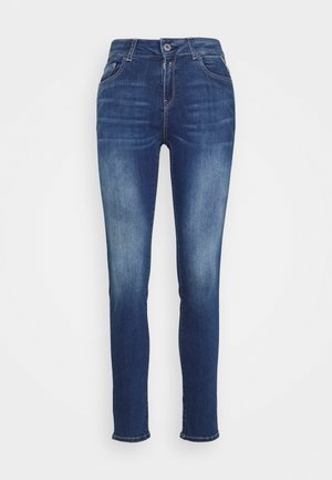 Jeans justos feitos de denim azul escuro, com uma cintura alta, cinco bolsos, costura visível e um fecho padrão com botão e fecho zip.