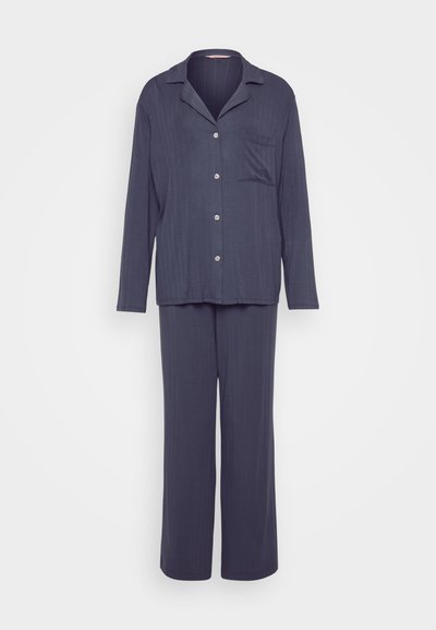 Navy blue pajama set featuring a button-up top with a pocket and long pants, made of soft ribbed fabric with a relaxed fit.