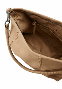 Tan leren tas met een zachte textuur, voorzien van een interne ritszak en stiksels aan de zijkant. Inclusief verstelbare schouderband.