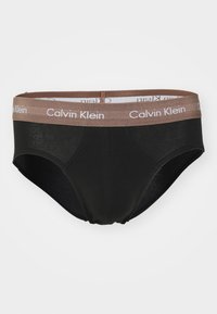 Zwarte herenbriefjes van een zachte stof, met een bruine elastische tailleband met het witte "Calvin Klein" logo. Klassiek briefontwerp.
