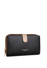 Portefeuille en cuir noir avec un rabat en cuir beige, fermeture zippée, logo "Lancaster Paris" embossé à l'avant, forme rectangulaire.