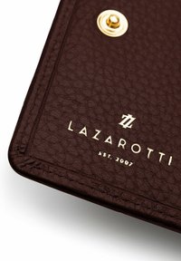 Cartera de cuero marrón oscuro con acabado texturizado, que presenta un logotipo dorado en relieve "LAZAROTTI" y la fecha de establecimiento, acentuada por un botón circular dorado.