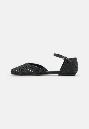 Black flat sandal with woven leather design, closed heel, open toe, and an ankle strap with a silver buckle.
