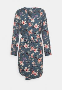 Blommig klänning i blått tyg med långa ärmar, v-ringning och ett självbindande bälte. Dekorerad med rosa, lila och vita blommönster.