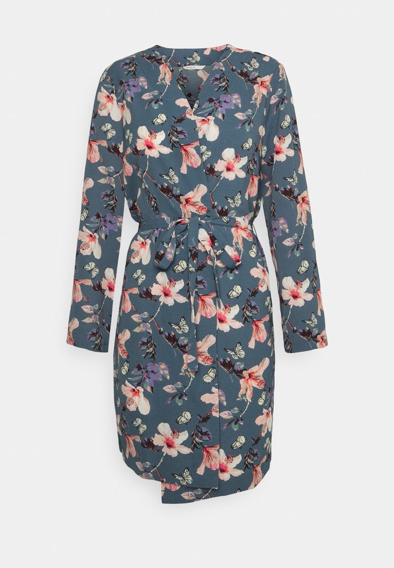 Blommig klänning i blått tyg med långa ärmar, v-ringning och ett självbindande bälte. Dekorerad med rosa, lila och vita blommönster.