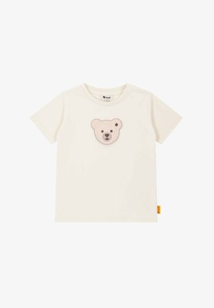 Cremefarbenes Baumwoll-T-Shirt mit einem weichen, gestickten Bärenkopf-Patch in hellbraun und dunklerem Braun auf der Brust. Kurze Ärmel und runder Ausschnitt.