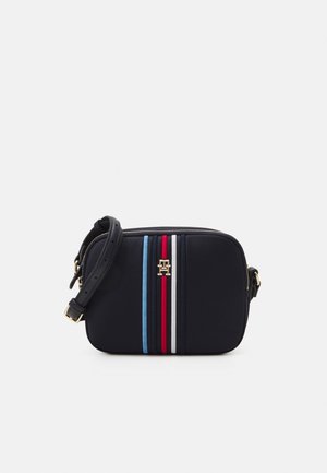 Petit sac bandoulière noir avec sangle ajustable, rayures verticales bleues, rouges et blanches, détail doré du logo centré à l’avant.