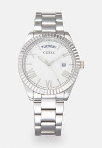 Silver stainless steel watch with a round white dial, Roman numerals, day display, and a polished bezel. Features a link bracelet design.