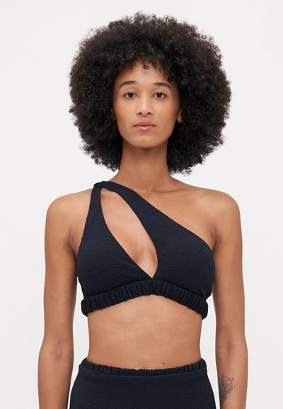 Black one-shoulder bikini top with textured fabric, asymmetrical cut, and a gathered band at the bottom. No additional patterns or accents.