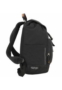 Sort rygsæk med en blød overflade, netstropper, delvis lynlås, sidelomme og et etiket, der beskriver dens formål og mærke.