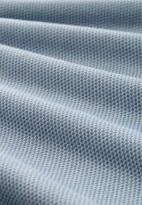 Tela de color azul claro con un diseño a cuadros, que presenta una textura suave y cuadrados oscuros y claros alternos.