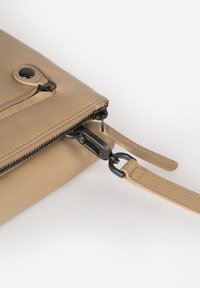 Tasche aus tanfarbenem Leder mit einem Reißverschluss, ausgestattet mit schwarzem Metall und einem abnehmbaren Tragegurt. Glatte Textur mit minimalen Nähdetails.