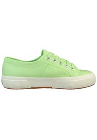 Jasnozielone płócienne sneakersy z okrągłym noskiem, teksturowaną powierzchnią, białą gumową podeszwą i srebrnymi oczkami na sznurówki. Minimalistyczny design.