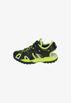 Sneaker nero e verde neon con pannelli in rete, cinturino regolabile e suola in gomma. Presenta un design resistente all'acqua per l'uso all'aperto.