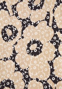 Motif floral abstrait beige et noir avec de grandes et petites fleurs couvrant densément une surface en tissu.