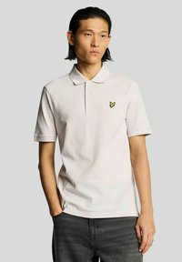 Lichtroze poloshirt van katoen, met een omgeslagen kraag, drieknopenbies en een klein geel vlindertje op de borst.