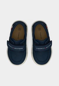 Μπλε παπούτσια από καμβά σε ναυτικό μπλε χρώμα με ιμάντα βέλκρο, λευκή λαστιχένια σόλα και λογότυπο μάρκας με κόκκινες και λευκές λεπτομέρειες, μέγεθος 20.